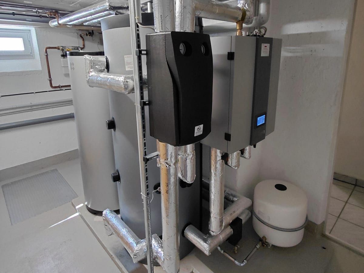 Technikraum mit Warmwasser- und Pufferspeicher, Regelung und gedämmten Leitungen
